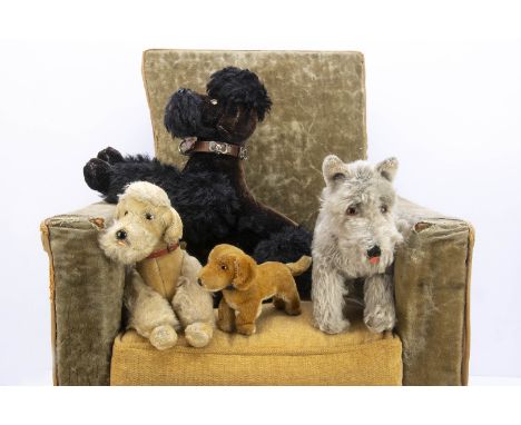 Four post-war Steiff dogs,  a black jointed Snobby poodle --12in. (31cm.) long; a Tessie schnauzer; a Bazi dachshund (some we