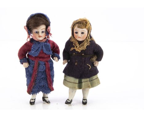 Two all-bisque dolls’ house dolls,  one with blue glass eyes, brown mohair wig, pin-jointed at shoulders and hips, blue felt 