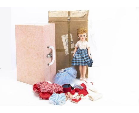 A Revlon vinyl doll in carry case,  with blue sleeping eyes, dark blonde hair and bottom stamped R V 15, four dresses and acc