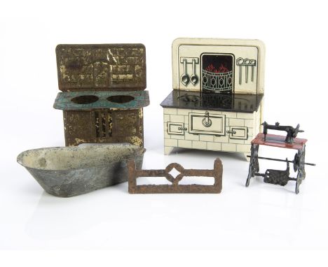 Small scale metal dolls’ house items, a cast-metal treadle sewing machine —1¾in. (4.5cm.) high; a lithographed cream tinplate