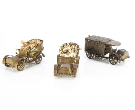 Three brass automobile novelties 1910-1920s, a pair of open back for holding chocolates? with white rubber tyres --5in. (13cm