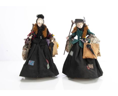 Two amusing artist doll Victorian bag ladies,  with painted wooden heads, wool hair, detailed clothes and props on stands, ba