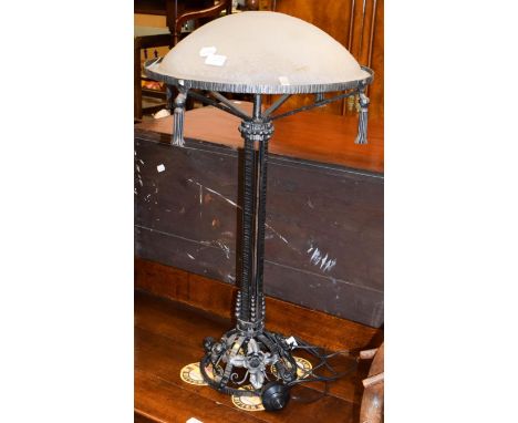 An Art Nouveau style wrought iron table lamp with a frosted glass shade indistinctly signed, 82cm high