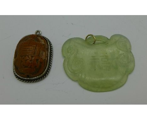 A jade pendant and an Egyptian scarab beetle pendant