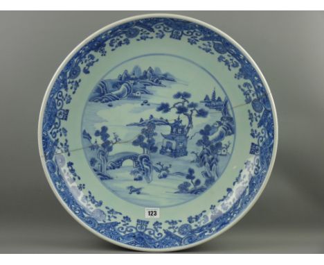 A large 19th Century Chinese deep dish charger, blue and white scroll pattern decoration with flowers and emblems to the rim 