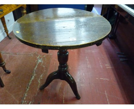 An antique oak circular top tripod table on a turned column support (feet reduced), 72 cms high, 62.5 cms diameter top