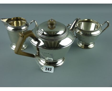 A three piece silver tea service comprising teapot of tapered form to a stepped pedestal and with composition handle and knop