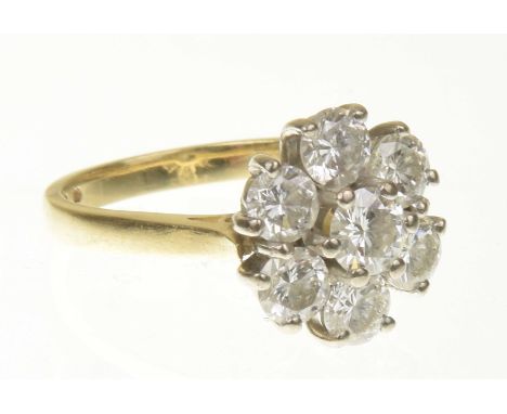 An 18ct gold diamond cluster ringThe brilliant cut diamond within a similarly cut diamond surround, estimated total diamond w