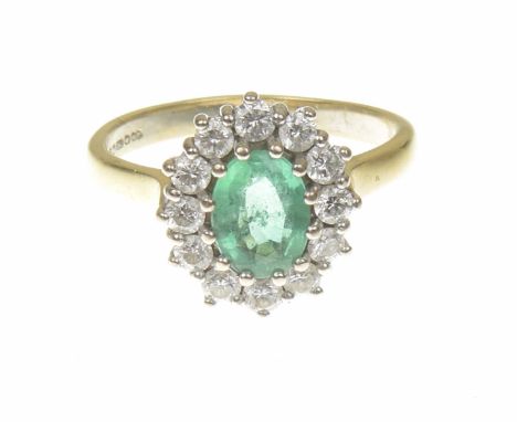 An 18ct gold emerald and diamond cluster ringThe oval shape emerald within a brilliant cut diamond surround, estimated total 