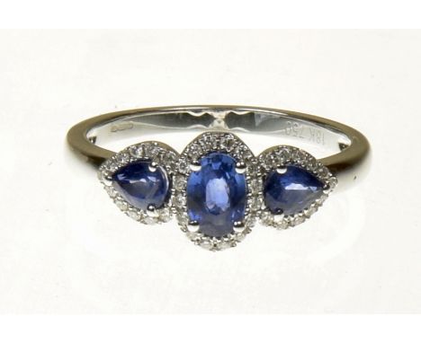 An 18ct gold sapphire and diamond cluster ringDesigned as an oval and pear shape sapphire line within a brilliant cut diamond