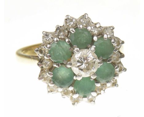 A 1980s 18ct gold emerald and diamond cluster ringThe brilliant cut diamond, within a circular shape emerald and similarly cu