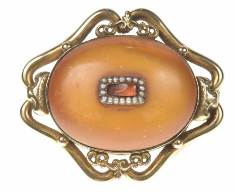 A mid Victorian amber broochThe rectangular orange gem panel within a split pearl surround, inset to the oval amber cabochon 