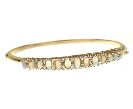 A late Victorian opal and diamond hinged bangleThe oval opal cabochon graduated line with rose cut diamond duo spacers, and p