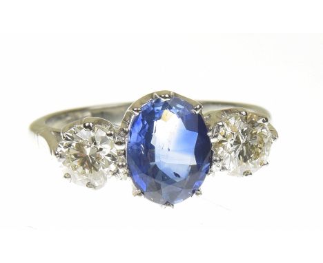 A sapphire and diamond three stone ringThe oval shape sapphire with brilliant cut diamond sides, stamped plat, estimated tota