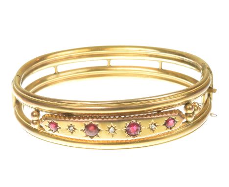 A late Victorian ruby and diamond bangleThe circular shape ruby and rose cut diamond front, with beaded trefoil sides and hin