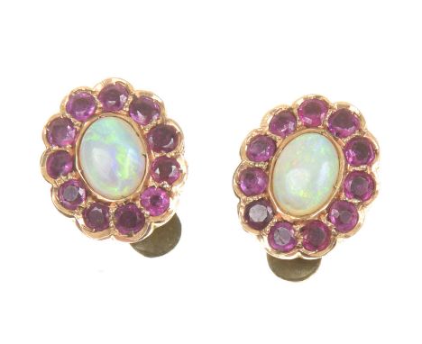 A pair of opal and ruby earringsEach designed as an oval opal cabochon within a circular shaped ruby scalloped surround, with