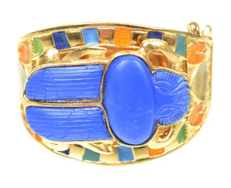 A 1970s Egyptian Revival scarab bangle, by Thomas Fattorini LtdThe large imitation lapis lazuli scarab beetle carving, atop t