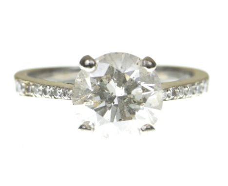 A diamond solitaire ringThe brilliant cut diamond with similarly cut diamond shoulders, stamped 18k, accompanied by a report 