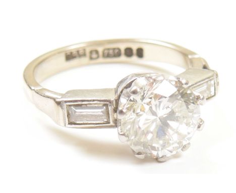 An 18ct gold diamond single stone ringThe brilliant cut diamond, with baguette cut diamond sides, estimated total diamond wei