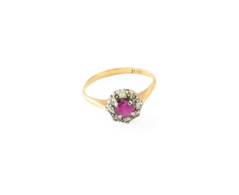 A Ruby and Diamond Cluster Ring, the round cut ruby within a border of eight-cut diamonds, in white claw settings, to a yello