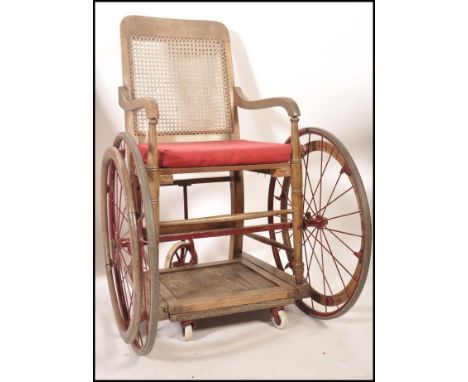 A rare early WWI First World War period cane back wheelchair / invalid chair. Original painted cast iron rims with retractabl