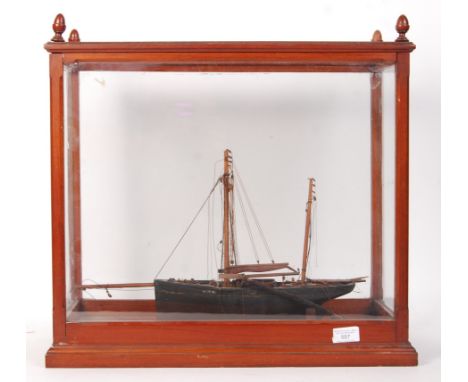 An antique late 19th / early 20th century scratch built model of a fishing boat vessel. Mounted within a glass display cabine