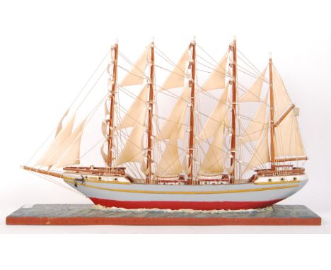 A museum quality hand made antique style wooden scratch built model of a sailing ship. Raised on a naturalistic sea base, the