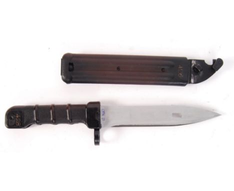 A post WWII Second World War / Cold War era rifle bayonet and scabbard. The blade having a serrated edge to one side and hand