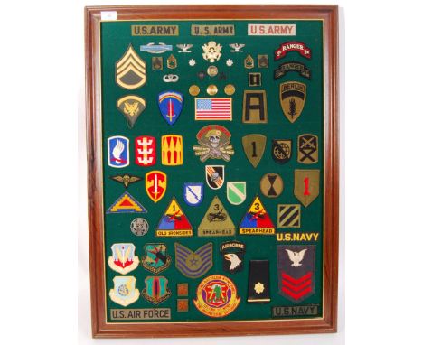 An assorted framed collection of U.S Army patches and cap badges from 20th Century conflicts to include ' Special Forces ' ' 