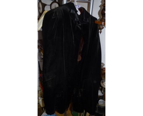 A lady's fur coat and a black velvet cape.