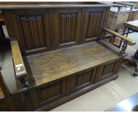 A 1920s oak linen fold hall bench, with rising seat, length 4'2" overall height 3'1", depth 1'6".