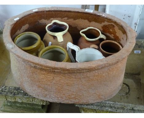 An oval terracotta planter, salt jars, jugs, etc.
