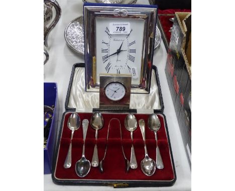 A silver fronted miniature clock by R Carr, another and a cased set of teaspoons and tongs.