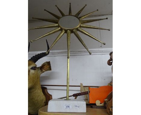 A sunburst mirror on marble stand.