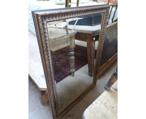 A modern gilt framed bevelled edge rectangular wall mirror.