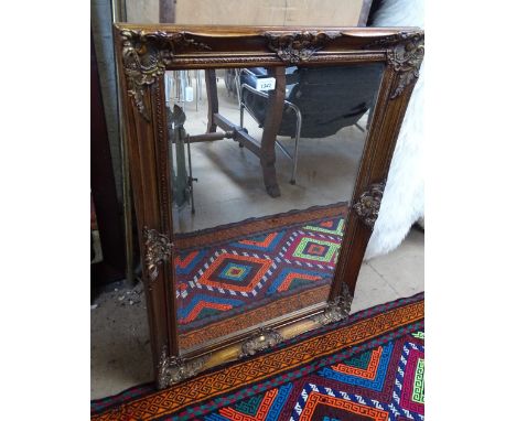 A modern gilt framed bevelled edge wall mirror.