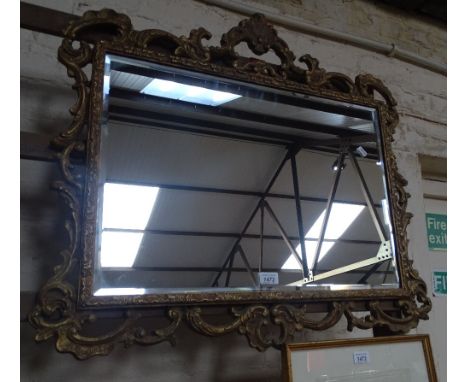 A bevelled edge wall mirror in a carved and pierced giltwood frame.