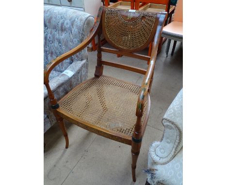 A Regency style painted mahogany desk chair with cane panelled back and seat.