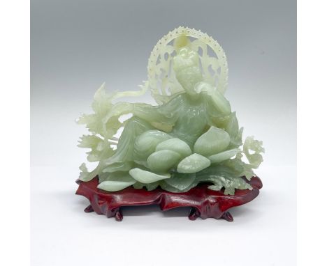 A beautiful light green gemstone of the Bodhisattva of compassion, lounging on her lotus throne while she is pouring water fr