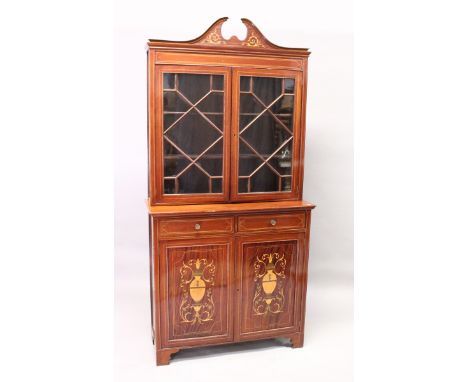 AN EDWARDIAN MAHOGANY STANDING BOOKCASE, the top with swan neck pediment, pair of glazed doors over a base with pair of marqu
