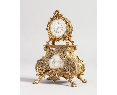 A MINIATURE GILDED CLOCK, rococo case with painted panel, 7 inches high