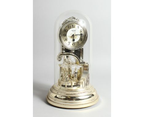 A QUARTZ CLOCK in a domed cover, 11 ins high.
