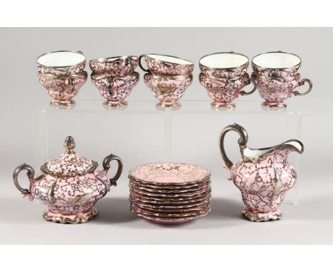 A ROSENTHAL SILVER OVERLAID PINK PORCELAIN TEA SET comprising ten cups and saucers, sugar basin and cover and milk jug