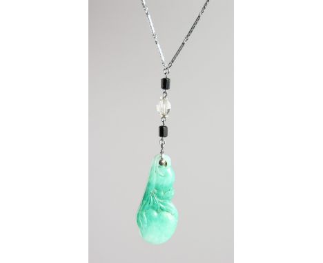 A CARVED JADE PENDANT on a chain.