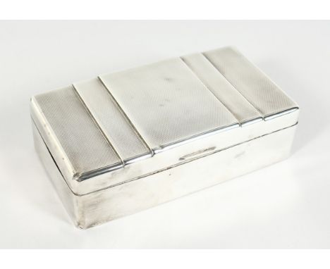 AN ENGINE TURNED &amp; PLAIN SILVER CIGARETTE BOX with cedar wood liner, 6.25 inches long, London 1935.