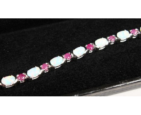 AN OPAL AND RUBY SILVER TENNIS BRACELET.