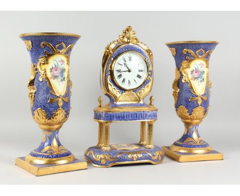 AN ITALIAN THREE PIECE CLOCK GARNITURE comprising blue and gilded clock, painted with flowers, 19 in. high and a matching pai
