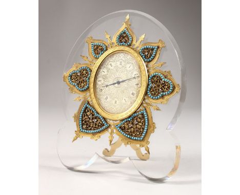 A SUPERB STRUTT CLOCK, on a shaped crystal frame, the oval dial with fine engraving, surrounded by seven various shapes with 