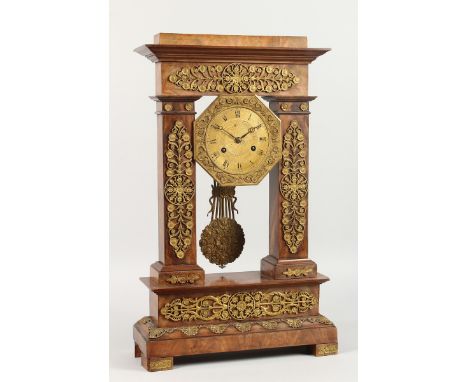 A GOOD 19TH CENTURY FRENCH EMPIRE WALNUT AND ORMOLU PILLAR CLOCK with swing pendulum. 20ins high.