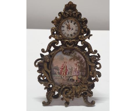 A hand painted miniature portrait of a Georgian couple housed in a brass frame with small time piece above overall dimensions
